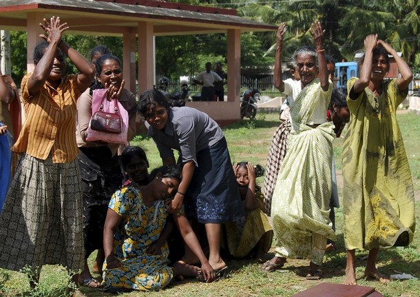 Relatives mourn over the burial site of seven ethnic Tamil civilians in Vavuniya