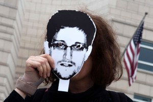 Woman holds a portrait of former U.S. spy agency contractor Snowden in front of her face as she stands in front of the U.S. embassy during a protest in Berlin