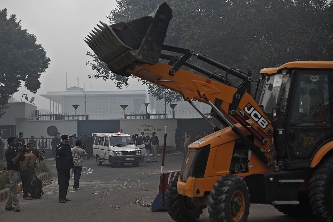 A bulldozer removes the security barriers in front of the U.S. embassy in New Delhi December 17, 2013. Indian authorities removed security barriers in front of the U.S. embassy in New Delhi on Tuesday apparently in retaliation for the arrest and alleged heavy-handed treatment of an Indian diplomat in New York. New Delhi police used tow trucks and bulldozers to remove the concrete barricades, which are used to restrict traffic on the road outside the embassy 