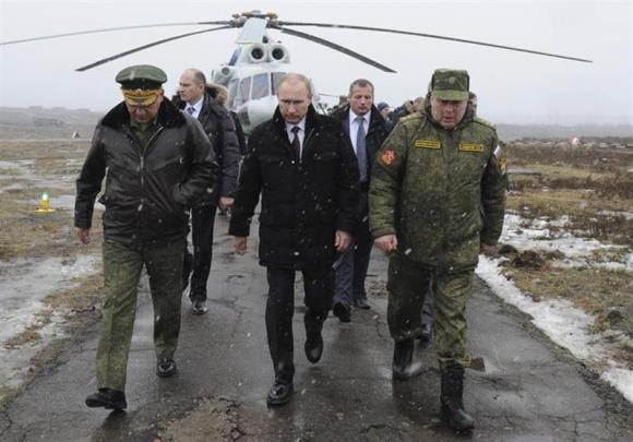 Russia's President Vladimir Putin (front C), accompanied by Russian Defence Minister Sergei Shoigu (front L), walks to watch military exercises upon his arrival at the Kirillovsky firing ground in the Leningrad region, March 3, 2014. REUTERS/Mikhail Klimentyev/RIA Novosti/Kremlin